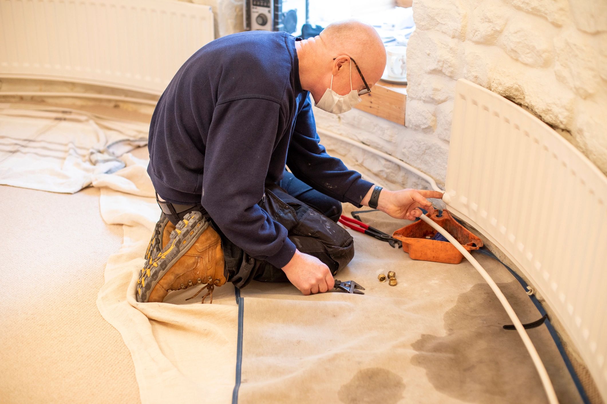 Professional plumber repairing a pipe during an urgent service call