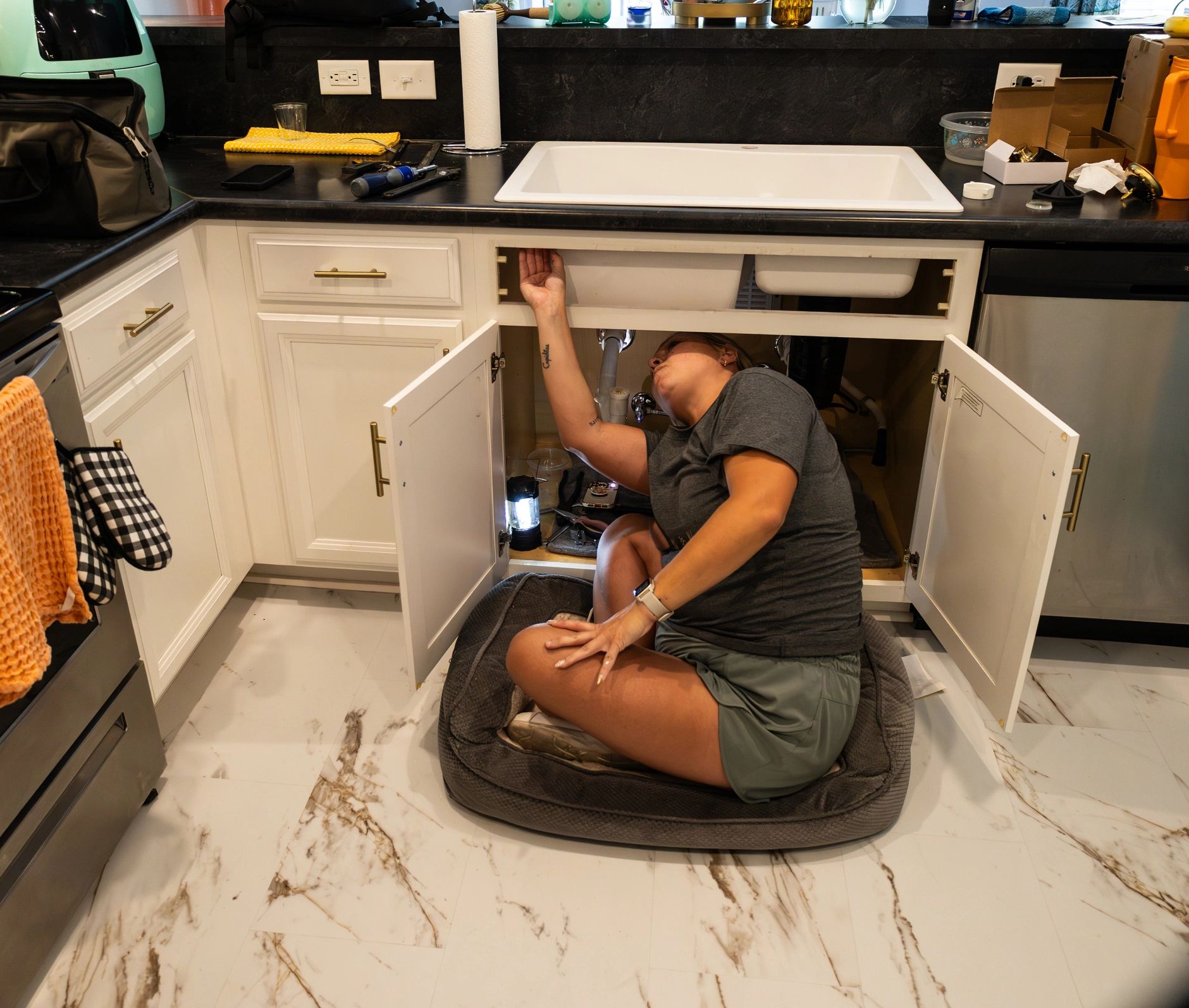 Plumber working under sink during plumbing repair